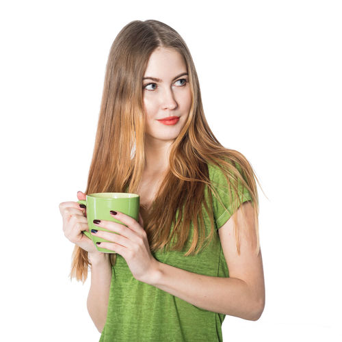Portrait of a beautiful young woman drinking against white background