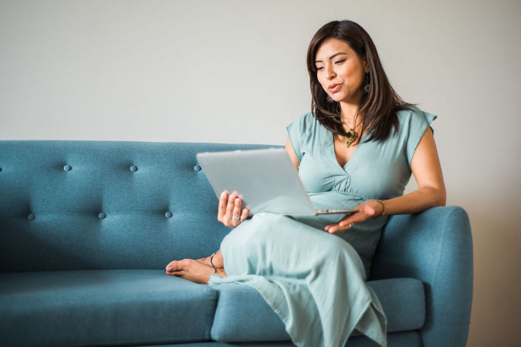 Young woman sitting on sofa at home