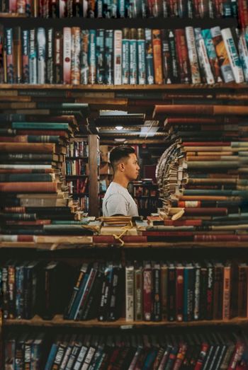 Man standing amidst books in library