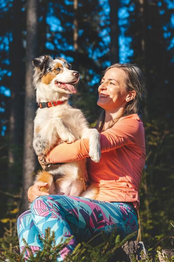 Candid portrait of young female athlete with her running and hiking partner, an australian shepherd