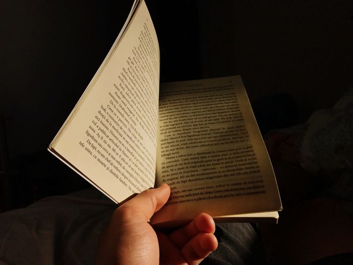 Midsection of person reading book on paper