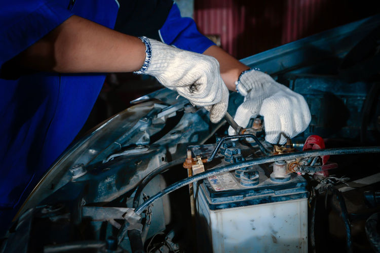 Midsection of man repairing car