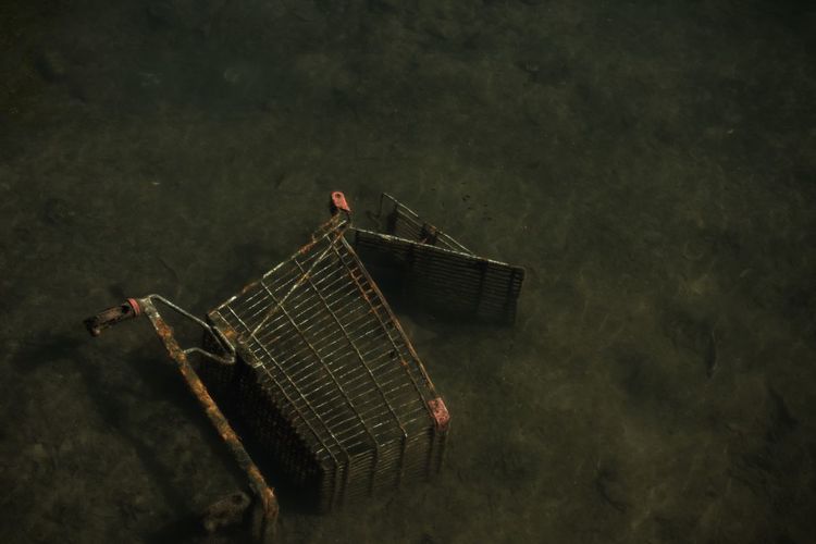 High angle view of abandoned shopping cart in river