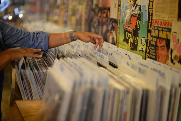Cropped image of person searching vinyl records at store