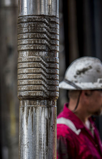 Worker walks past pipe junction on offshore platform