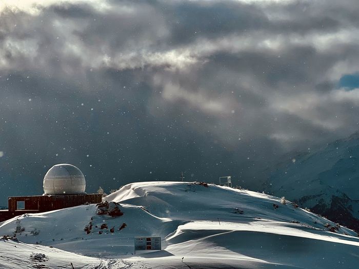High angle view of snow covered mountain against sky at night