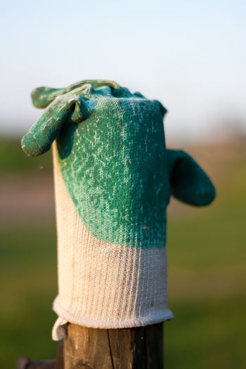 Close-up of gardening glove on wooden post