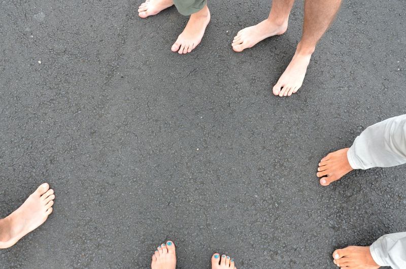Low section of people standing on asphalt