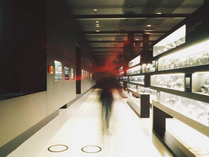 Woman walking in illuminated corridor
