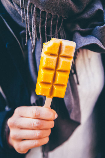 Midsection of person holding ice lolly in autumn