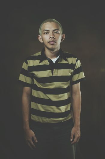 Portrait of young man over black background