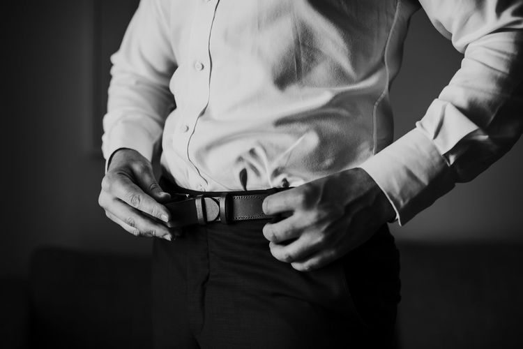 Midsection of man wearing belt