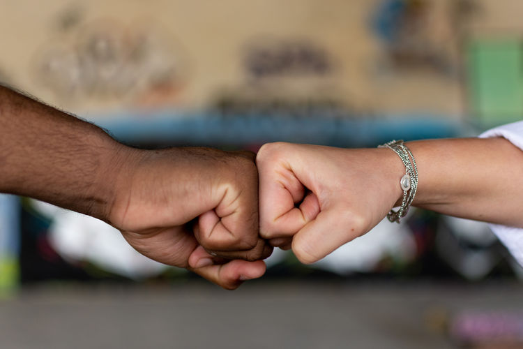 Black man and white woman clenching their fists. union concept. stop racism. graffiti wall