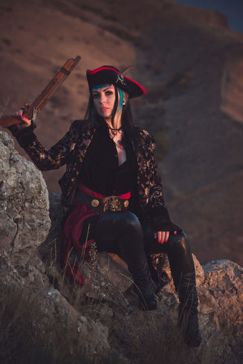 Portrait of a pirate woman at the beach. in anticipation of a pirate ship, sunset