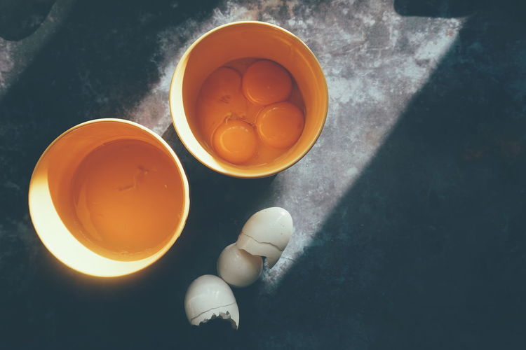 High angle view of egg yolks in containers on table