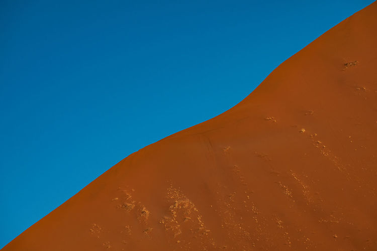 Sand dune profile against blue sky in namib desert 