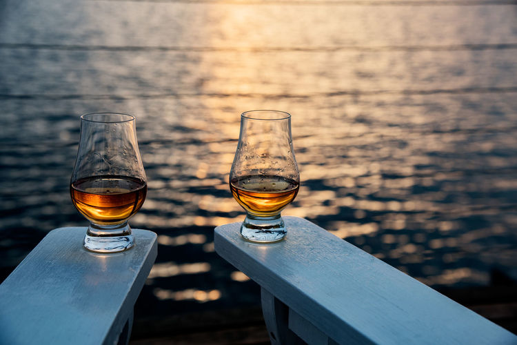 Close-up of drinks against blurred water