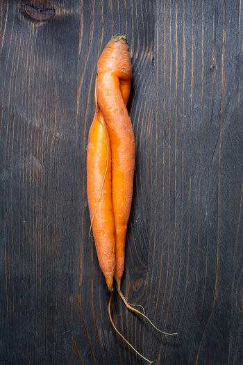 Unusual carrot on wooden surface
