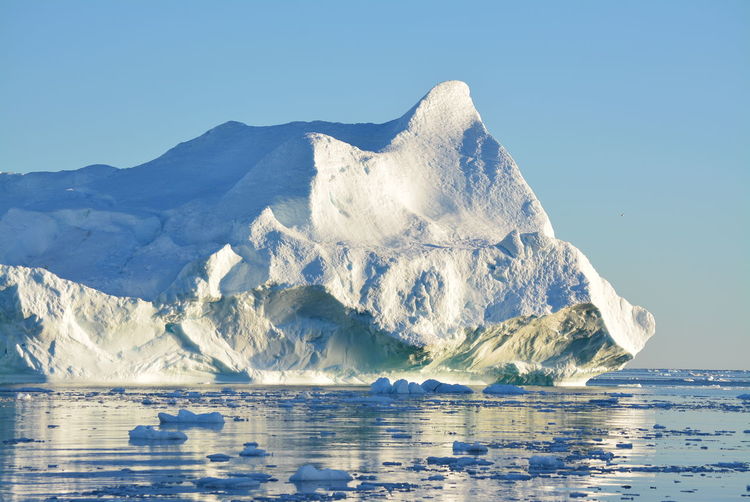 View of majestic iceberg in sea against sky