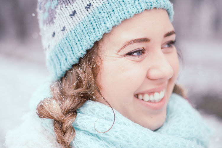 Close-up of smiling young woman at park during winter