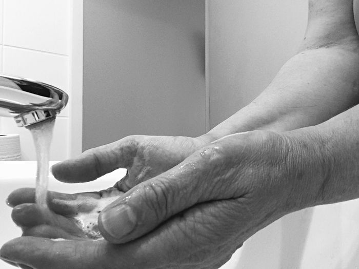 Cropped image of man washing hands in bathroom at home