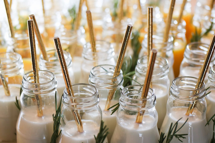 Close-up of jars with milk and drinking straws