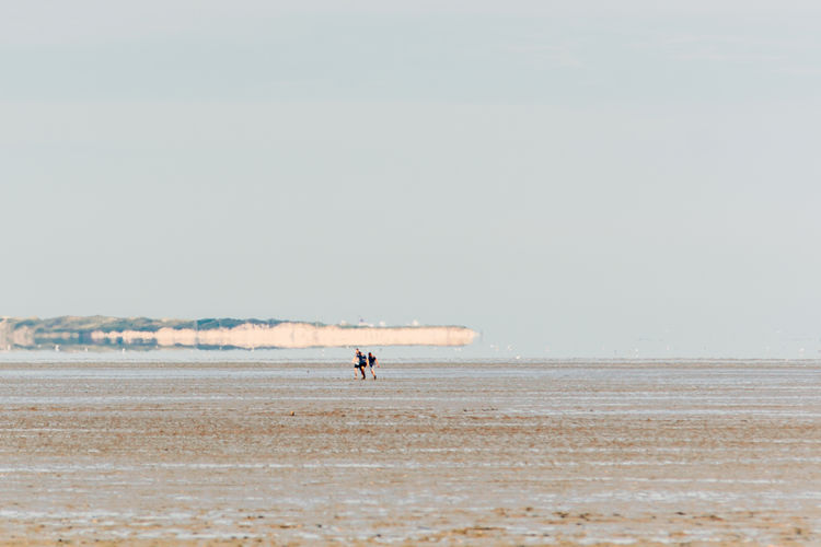 Distant view of man on beach against sky