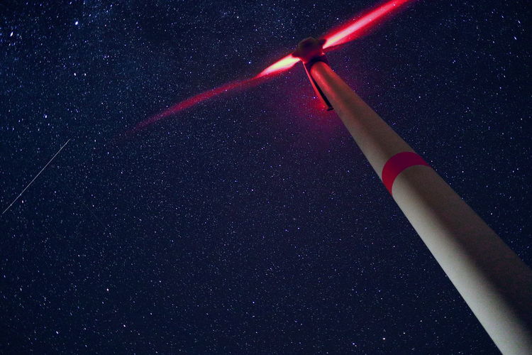 Low angle view of illuminated lighting equipment at night