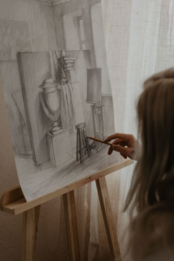 Close-up of woman painting, drawing with a pencil, artist