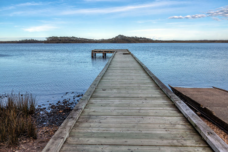Pier over lake against sky