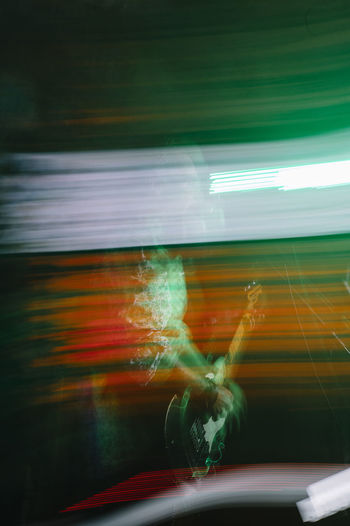 Blurred scene of guitar player playing an electric guitar on stage