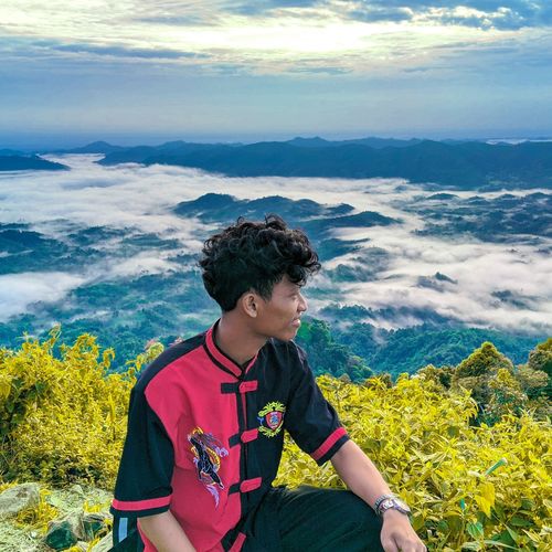 Smiling young man looking at view on mountain