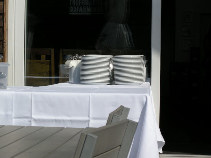 Stacked empty plates on table at outdoor restaurant