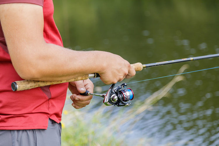 A man with a beard is fishing on the river.