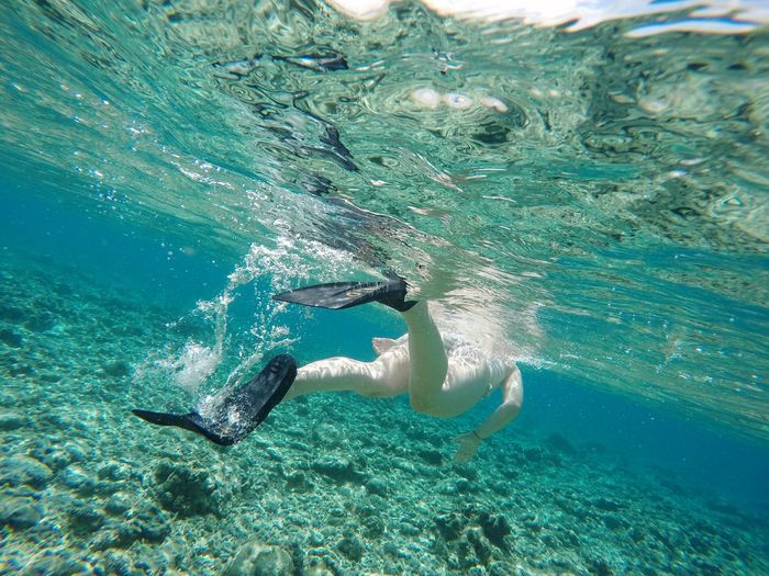 Low section of woman swimming in the sea