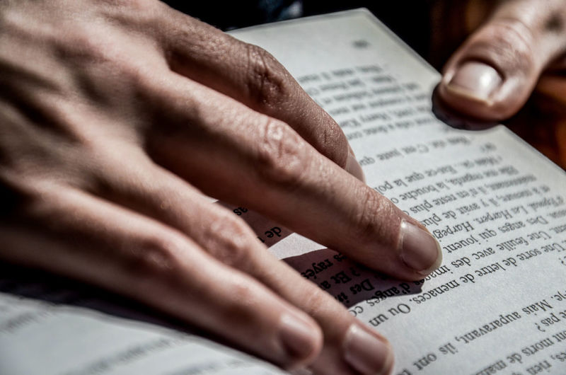 Cropped image of hands holding book