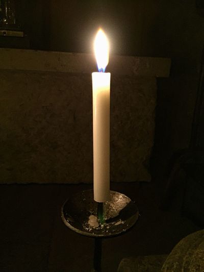 Close-up of lit tea light candles in darkroom