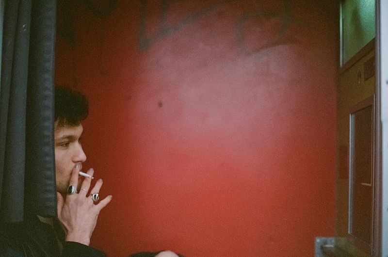 Side view of young man smoking cigarette