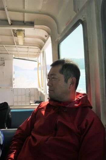 Portrait of man sitting in small ferry