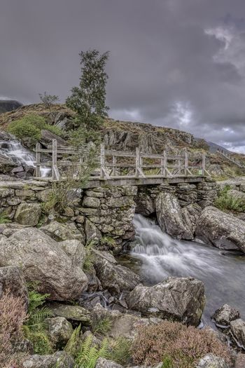 Water flowing through rocks against sky