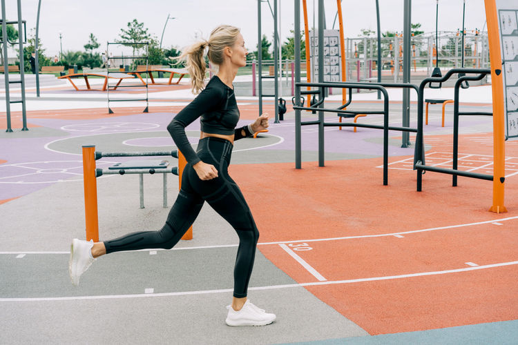 Young woman runner trains on the sports ground. person