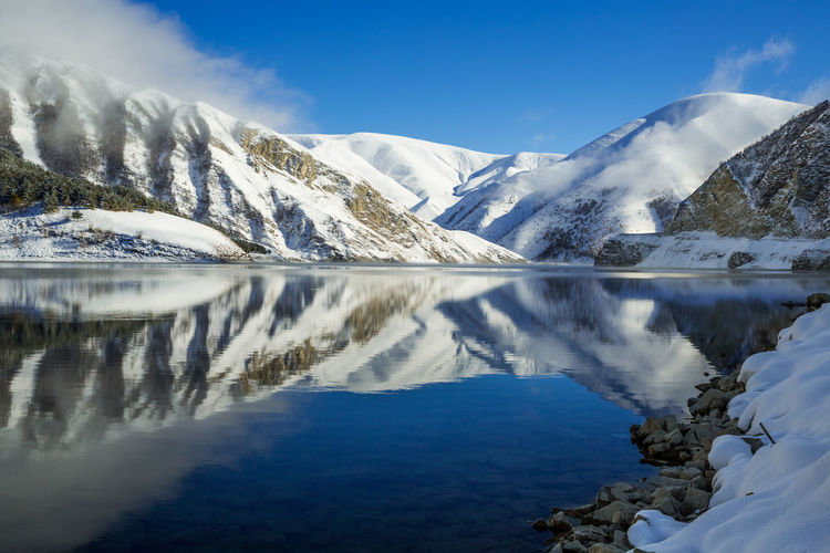 Beautiful mountain lake in winter. scenic view of lake and snowcapped mountains against sky