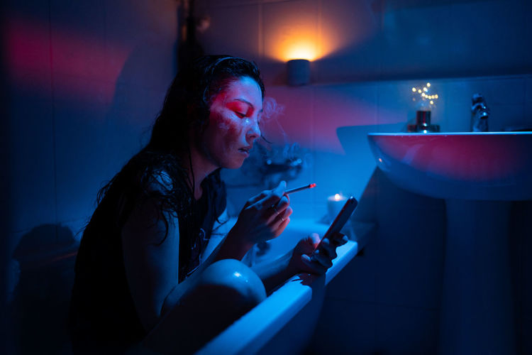 Sad girl drunk in bath smoke jealous follow ex boyfriend in social media, communicate in dating app