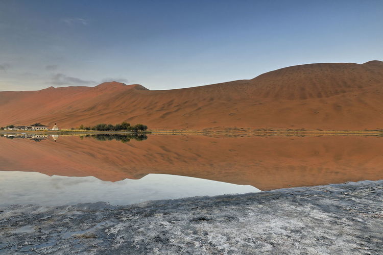 1125 sumu jaran lake and badain jaran desert temple-sand megadunes reflected on mirror water. china.