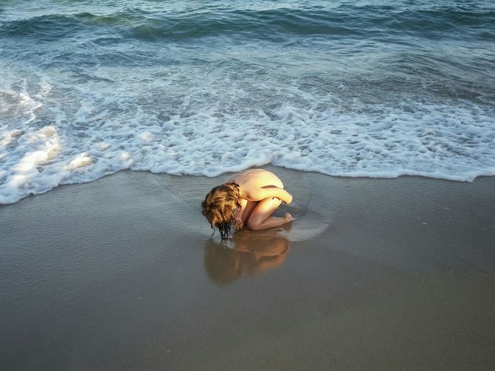 Naked child on shore at beach