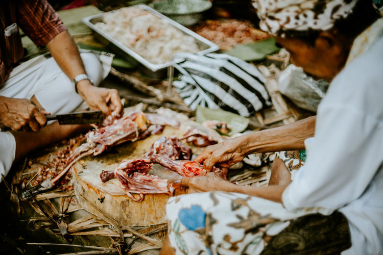 Midsection of man cleaning meat at market