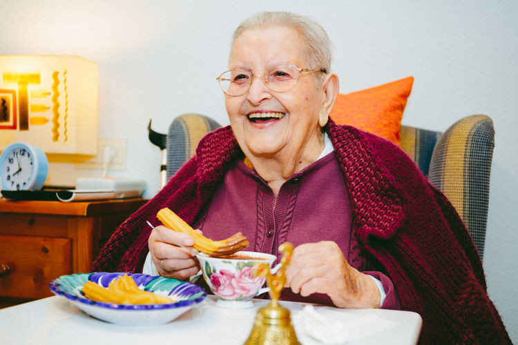 Portrait of senior woman eating churros