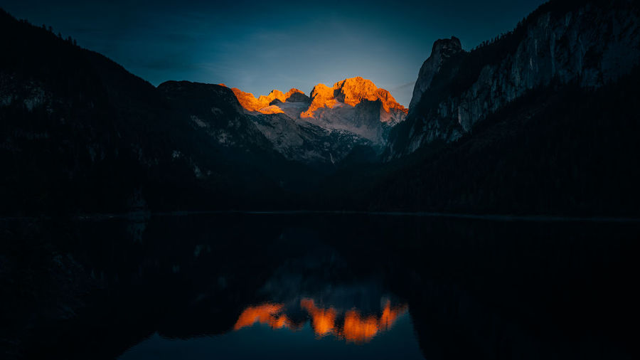 Reflection of mountains in lake at night