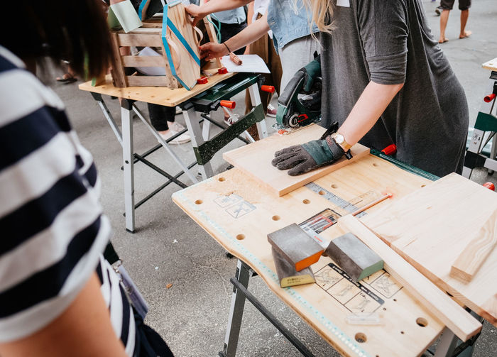 workshop project, creating with wooden material Crafts Workshop Adult Craft Craftsperson High Angle View Human Body Part Project Real People Standing Table Teamwork Women Workbench Working