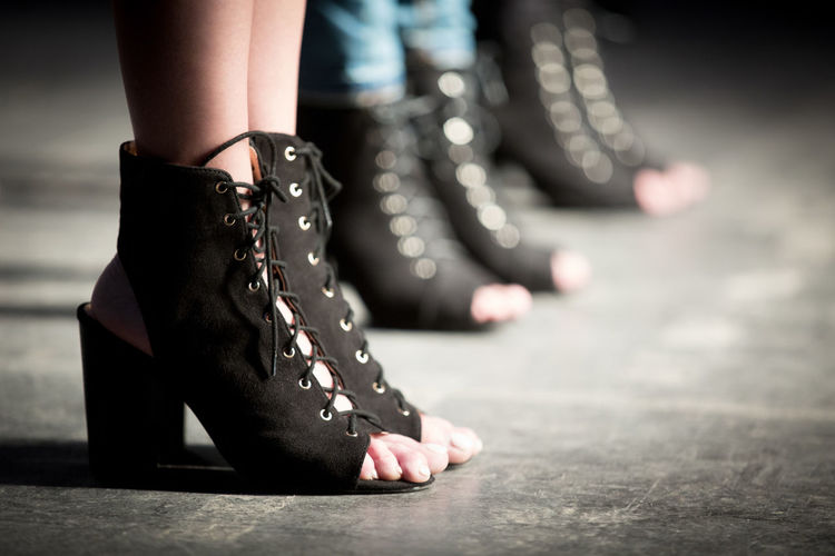 Low section of models wearing shoes on stage during fashion show